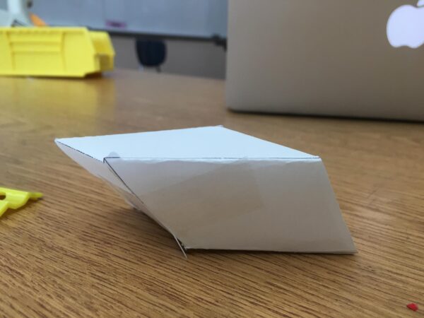 A 3D parallelogam made out of white paper.