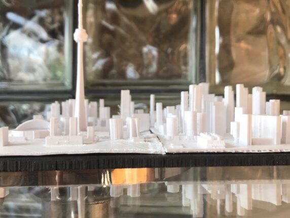 A white 3D printed replica of the Toronto skyline including the Canadian National Tower.