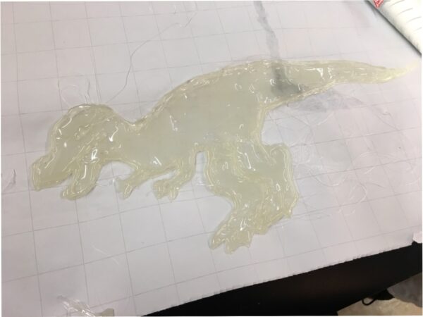 A profile of a small T-rex made out of melted glue.