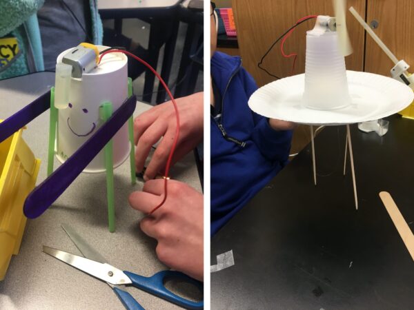 On the left is a picture of an upside down white paper cup with a smiley face. There are four green straws attached to the sides of the cup to make it stand. Two purple popsicle stick arms stick straigh out. A motor sits on the top. A short glue stick hangs down from the top. A student’s hands holds a red and black wire against a battery. On the right is a picture of a white paper plate standing on three toothpicks. On top of the plate is an upside down clear plastic cup. A motor is taped to the top of the cup. A red and a black wire come off the motor. A glue stick is attached to the shaft of the motor and spins.